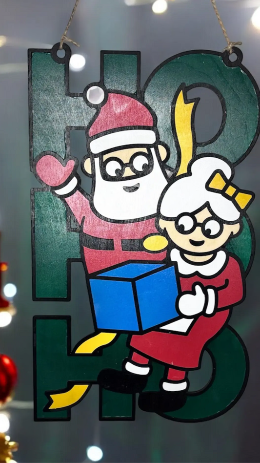 Handgjord juldekoration i trä med tomtefar och tomtemor som bär julklappar