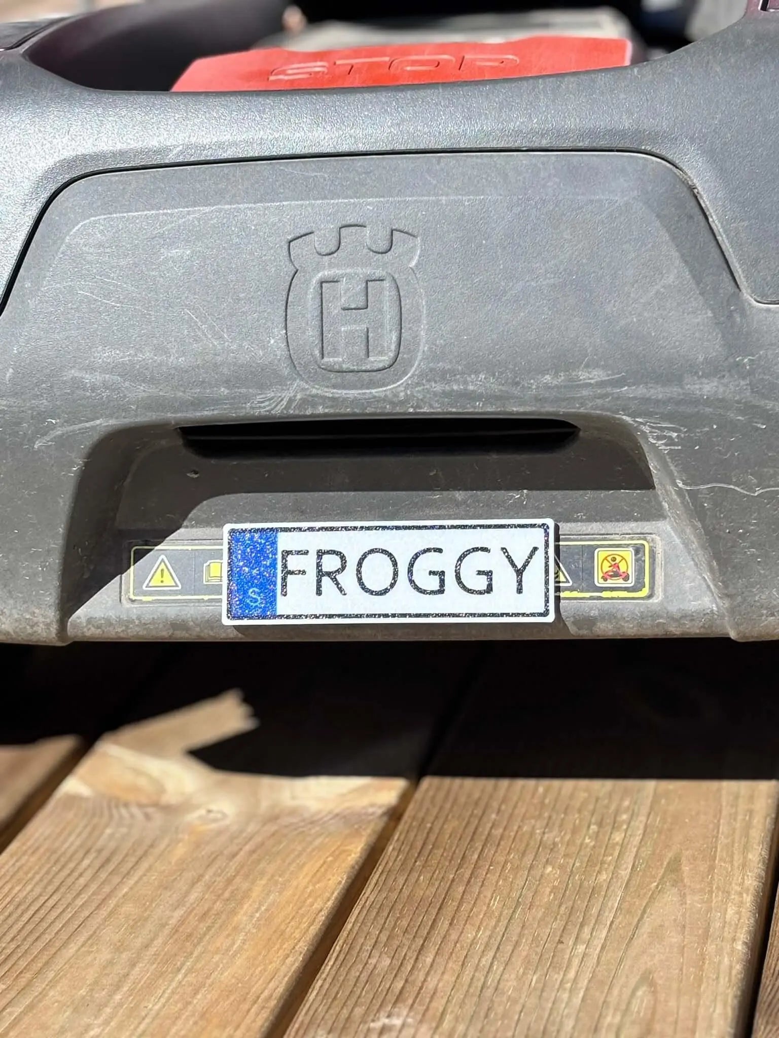 Närbild på namnskylt till robotgräsklippare med personlig text